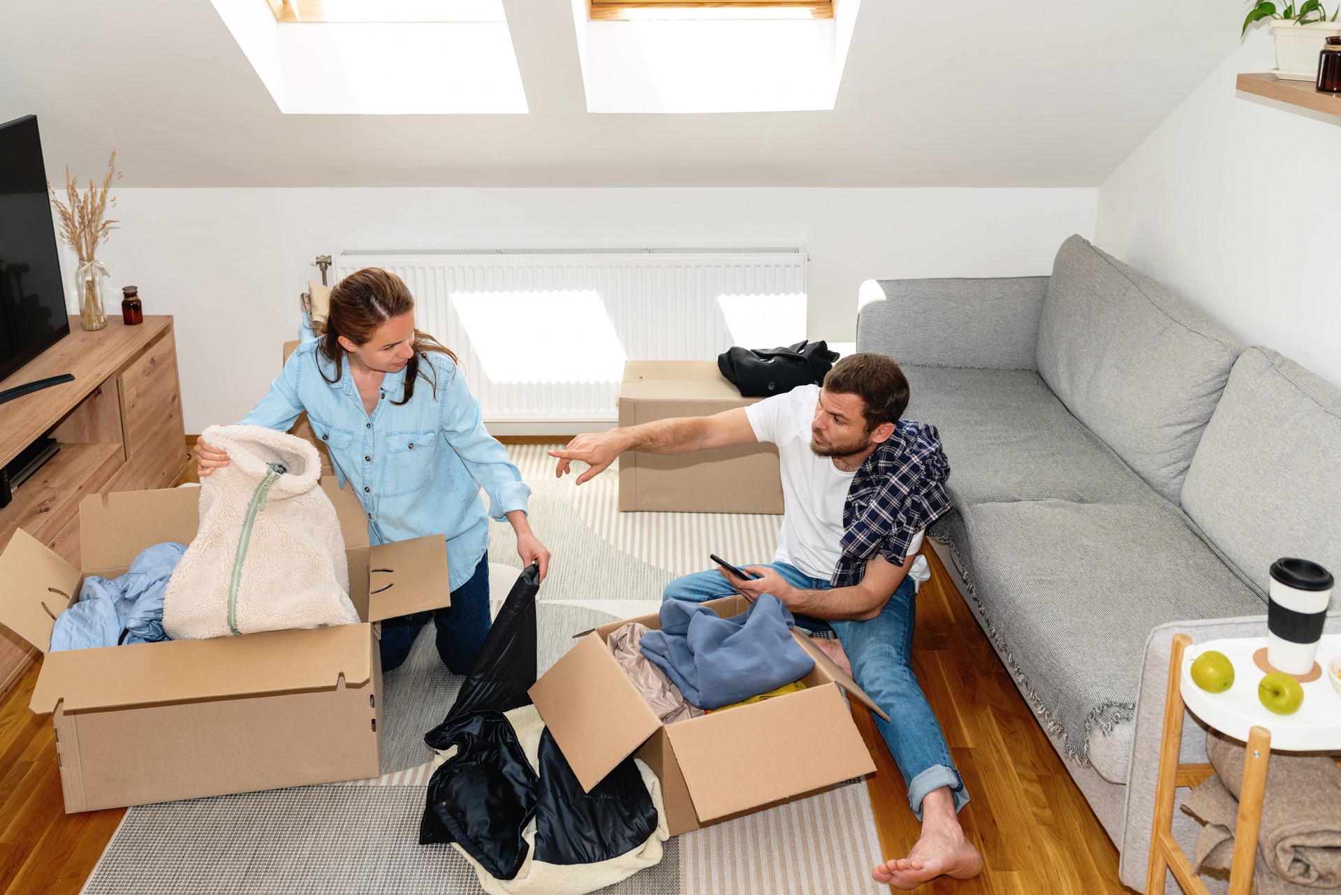 Young married couple packing their clothes for charitable organisation.